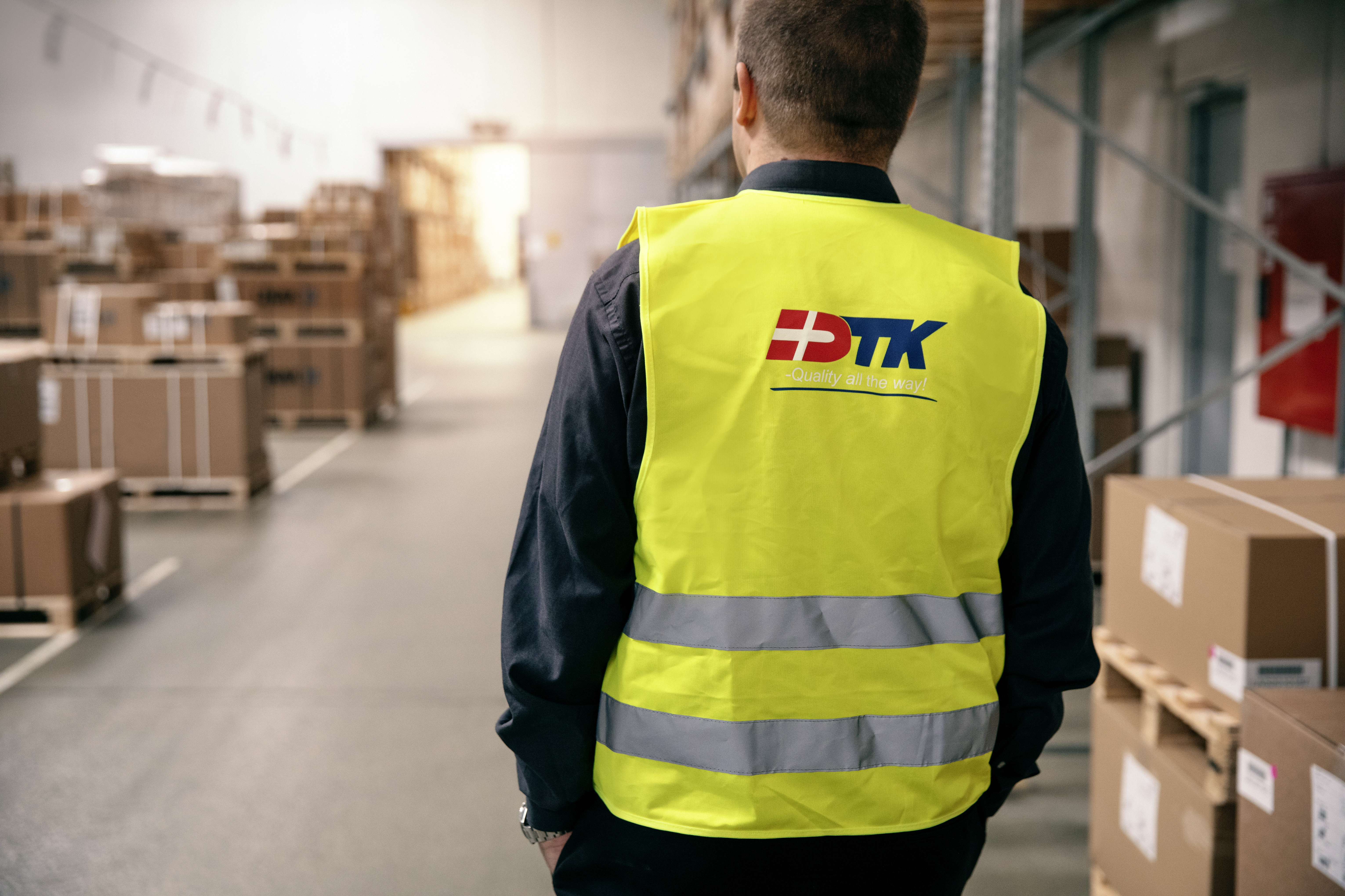Medarbejder fra DTK set bagfra med vest på